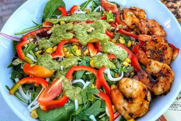 Spring mix, arugula, bell peppers, heirloom tomatoes, roasted corn, shredded jack cheese, pepita seeds, cilantro lime vinaigrette dressing on the side