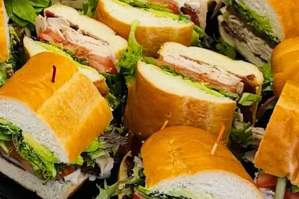 Each half sandwich is packed with crisp organic English cucumbers, juicy sliced tomatoes, house-made pickled onions, sliced pepper jack cheese, slow roasted red bell peppers, fresh baby sprouts, and creamy slices of freshly cut avocado. Finished with our signature house-made garlic aioli and a drizzle of balsamic glaze and Italian dressing on a freshly baked hoagie roll.