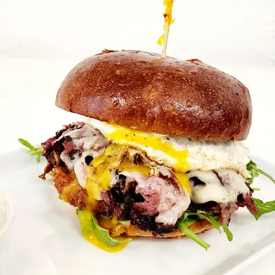 Brioche bun, pastrami, sunny-side up egg, Swiss cheese, arugula, thousand island dressing, garlic aioli, hash-brown with a dash of organic maple syrup