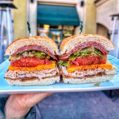 Sliced oven-roasted Turkey breast, Boar’s Head Salami, Boar’s Head thick cut bacon, Vermont cheddar cheese, shredded Romaine lettuce, house-pickled onions, tomatoes, spicy Italian seasoning, topped with House Italian dressing, house peppercorn sauce on a Dutch crunch roll