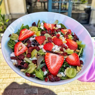 Spring mix, grapes, strawberries, pine nuts, dried cranberries, feta cheese, lemon honey dressing on the side.